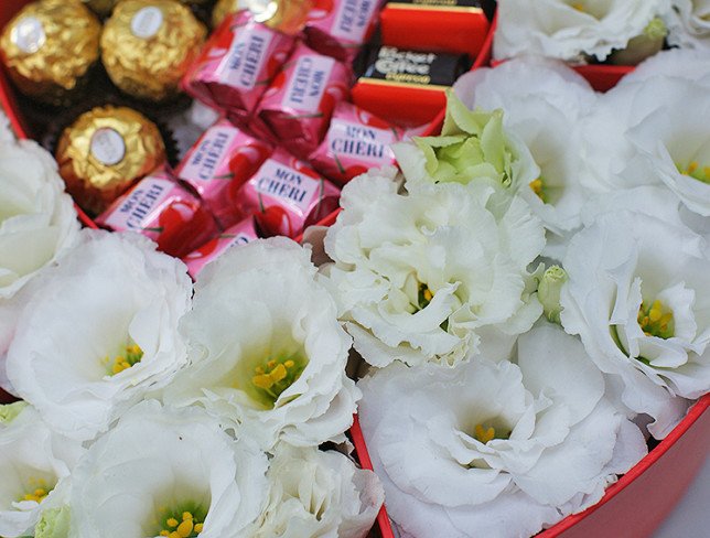 Box with white eustoma and sweets photo