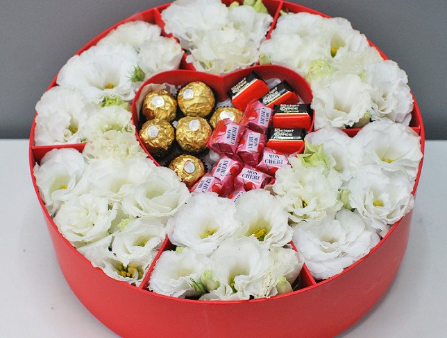 Box with white eustoma and sweets photo