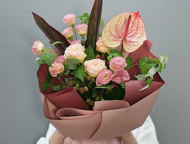 Bouquet of anthurium and raspberry branches 