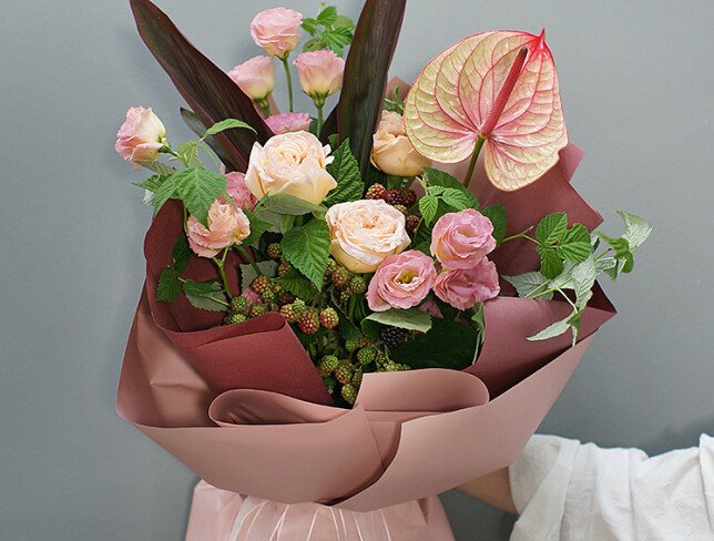 Bouquet of anthurium and raspberry branches 