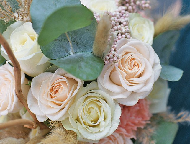 Bridal bouquet of white roses, carnations, ozotamnus and eucalyptus photo