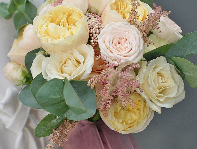 Bridal bouquet of cream roses, carnations, astilbe and eucalyptus photo