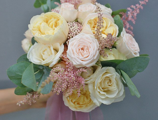 Bridal bouquet of cream roses, carnations, astilbe and eucalyptus photo