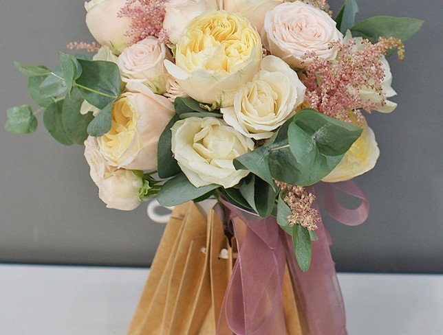 Bridal bouquet of cream roses, carnations, astilbe and eucalyptus photo