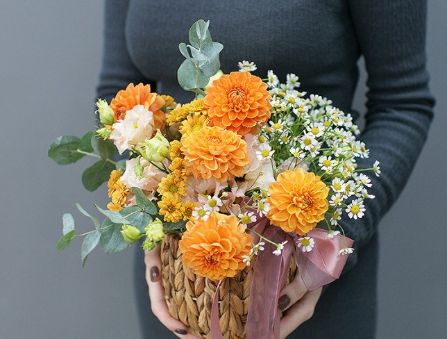 Basket with orange dahlias and chamomile photo