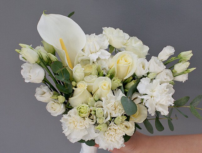Bridal bouquet with white roses, lisianthus, dianthus, and eucalyptus photo