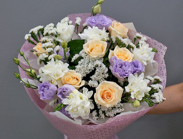 Bouquet of cream roses, white freesia, and eustoma photo