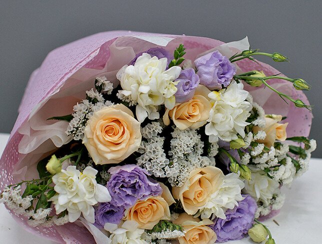 Bouquet of cream roses, white freesia, and eustoma photo