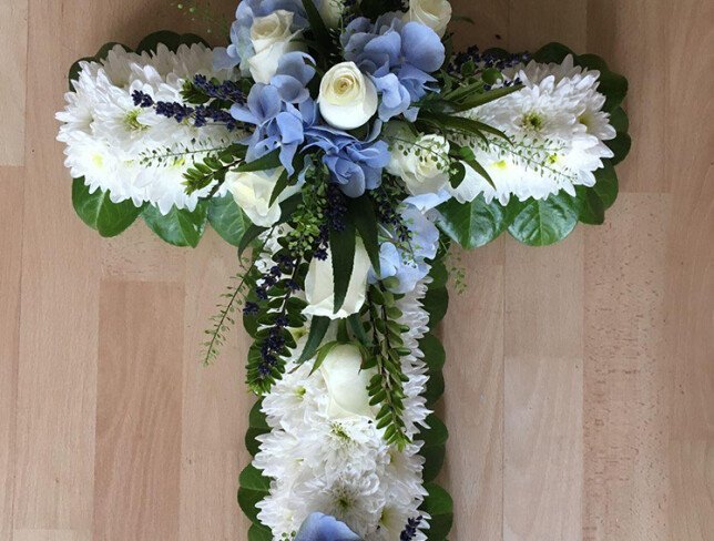 Funeral arrangement of blue hydrangea, chrysanthemums, roses, and lavender photo
