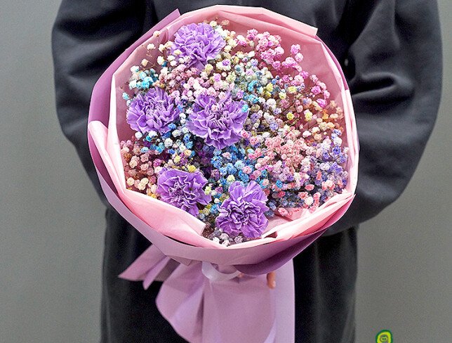 Bouquet of multicolored gypsophila and purple carnations photo