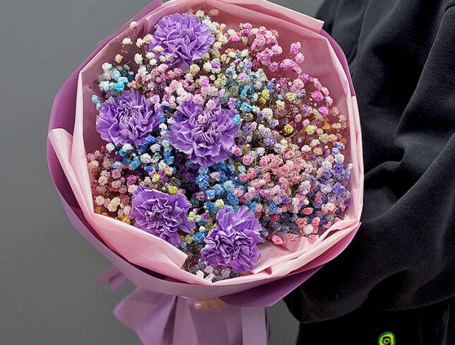 Bouquet of multicolored gypsophila and purple carnations photo