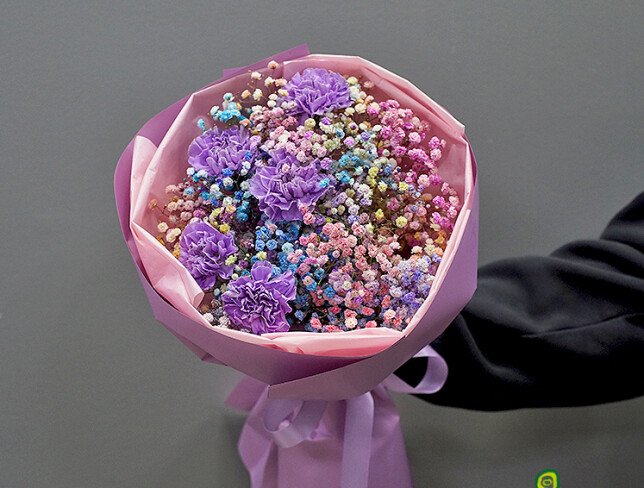 Bouquet of multicolored gypsophila and purple carnations photo