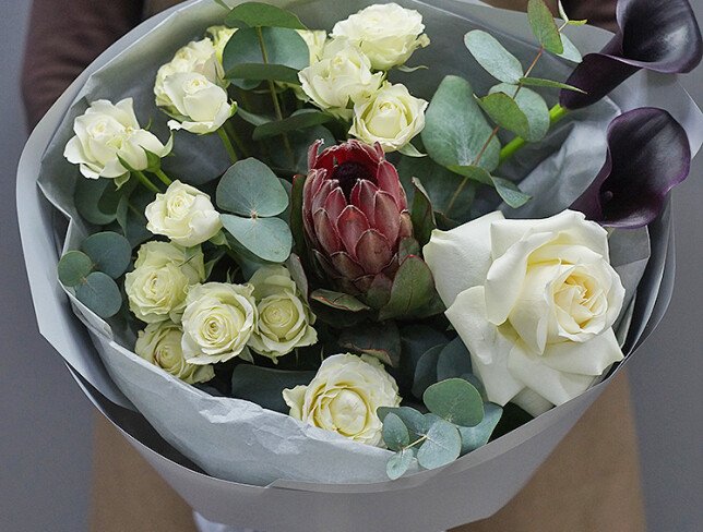 Bouquet of white spray roses, protea, and black calla lilies photo