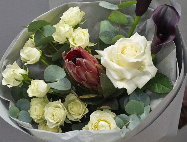 Bouquet of white spray roses, protea, and black calla lilies photo